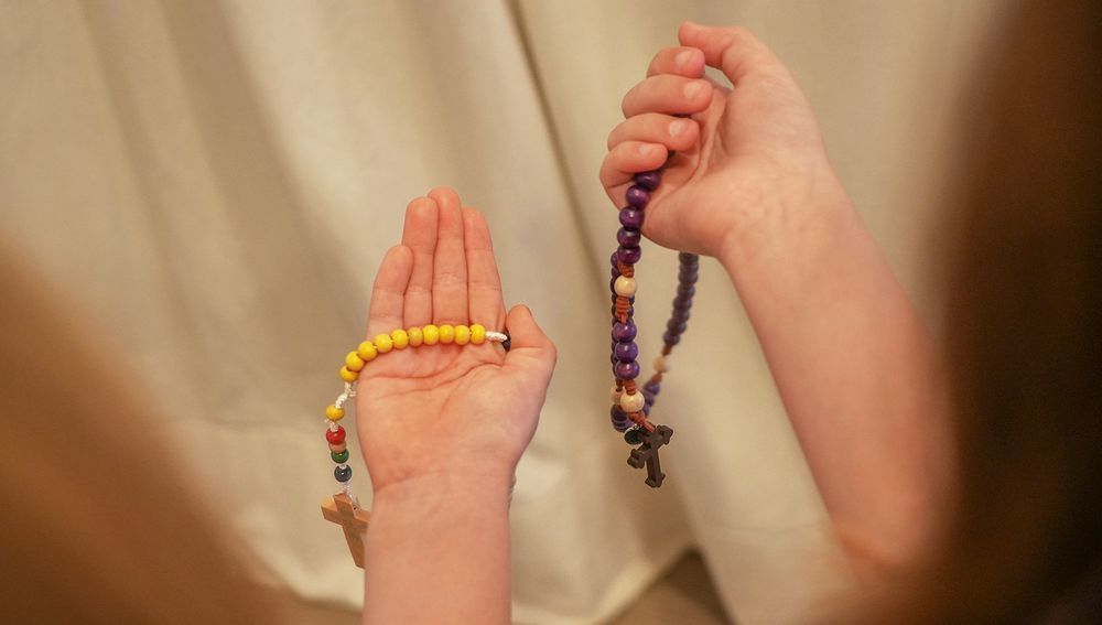 Hände mit Rosenkränzen