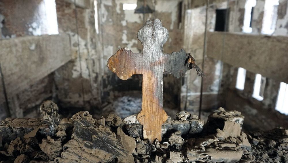 Verbranntes Kreuz in von Brandanschlag zerstörter Kirche