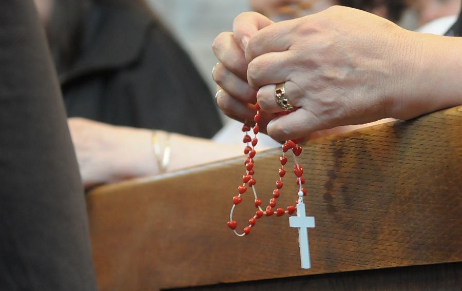 Frau betet Rosenkranz