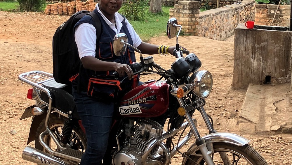 Caritas-Burundi-Landwirtschaftsberaterin Esperance Ndizeye auf Motorrad
