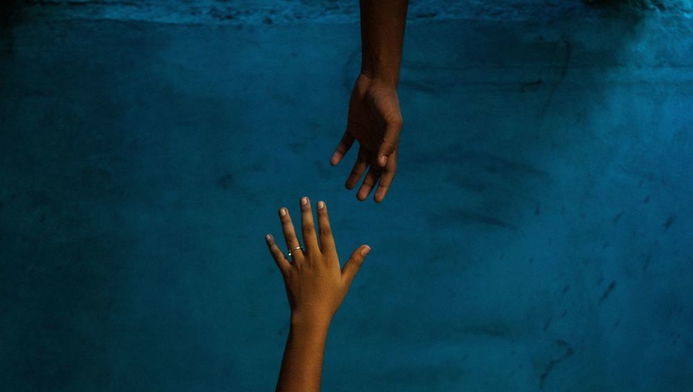 Zwei Hände, die nach einander greifen