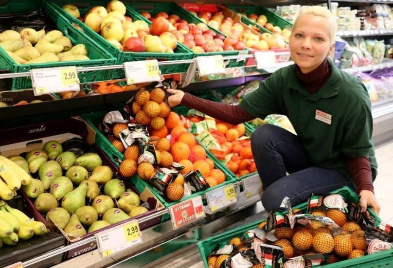 Supermarkt-Angestellte beim Obststand