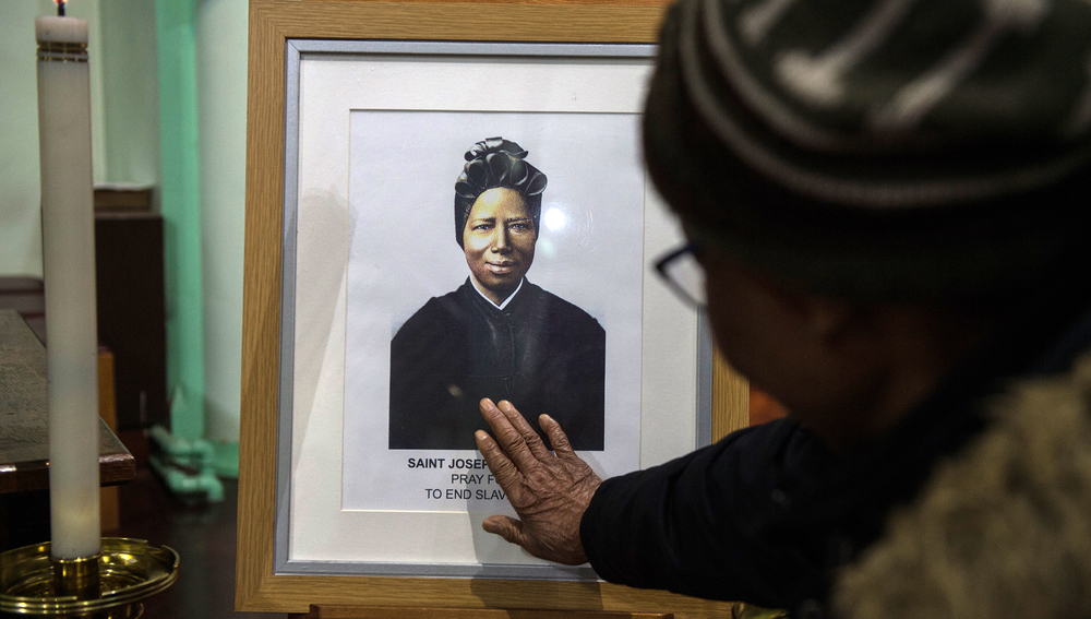 Frau berührt Bild der Heiligen Josephine Bakhita
