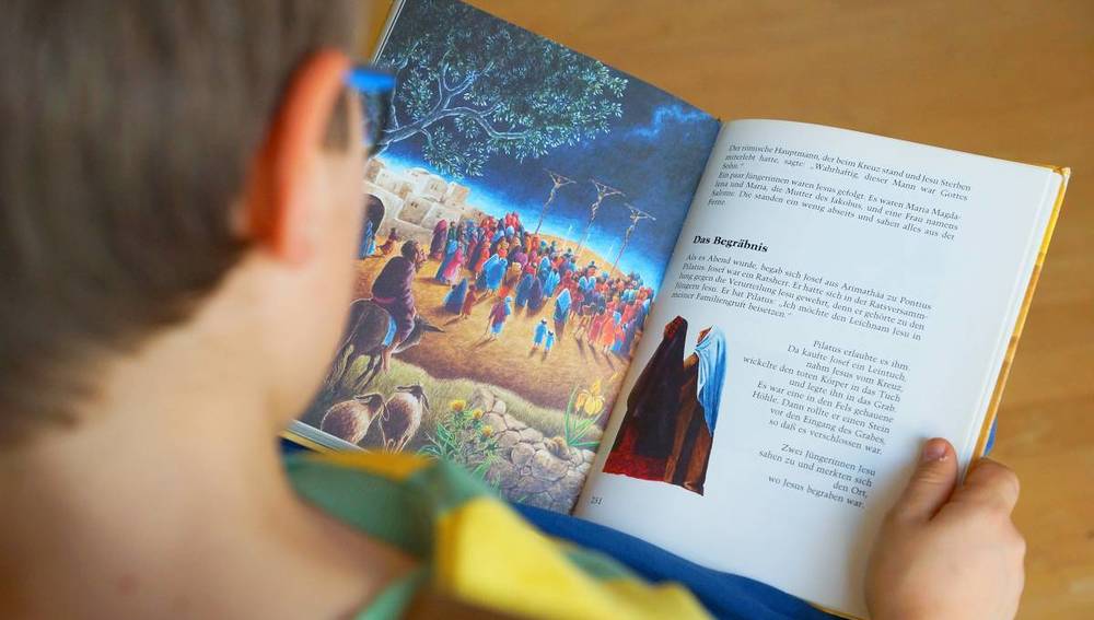 Kind liest in einer Kinderbibel