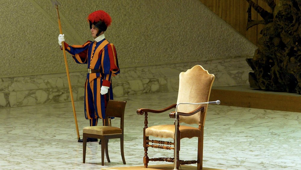 Ein Schweizer Gardist steht am 24. September 2003 neben dem leeren Stuhl von Papst Johannes Paul II., nachdem der Papst die wöchentliche Audienz aus gesundheitlichen Gründen absagen musste.Foto: REUTERS/Tony Gentile