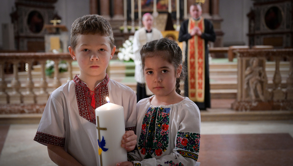 Kinder aus der Ukraine mit Kerze bei Friedensgebet in Salzburg