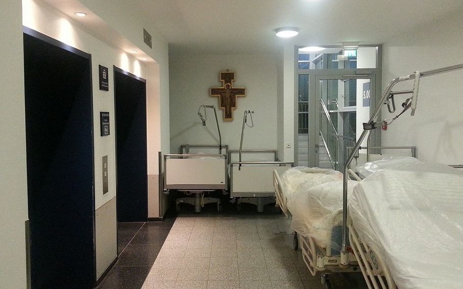 Spitalsbetten mit Kreuz im Hintergrund