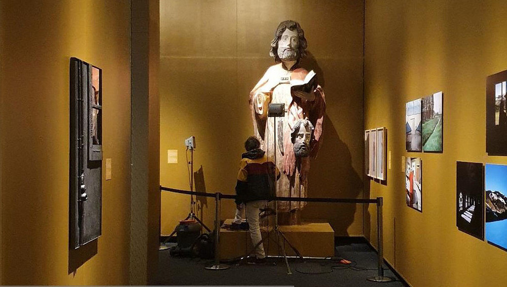 Künstler Abraham Poincheval vor Holzskulptur des heiligen Bartholomäus