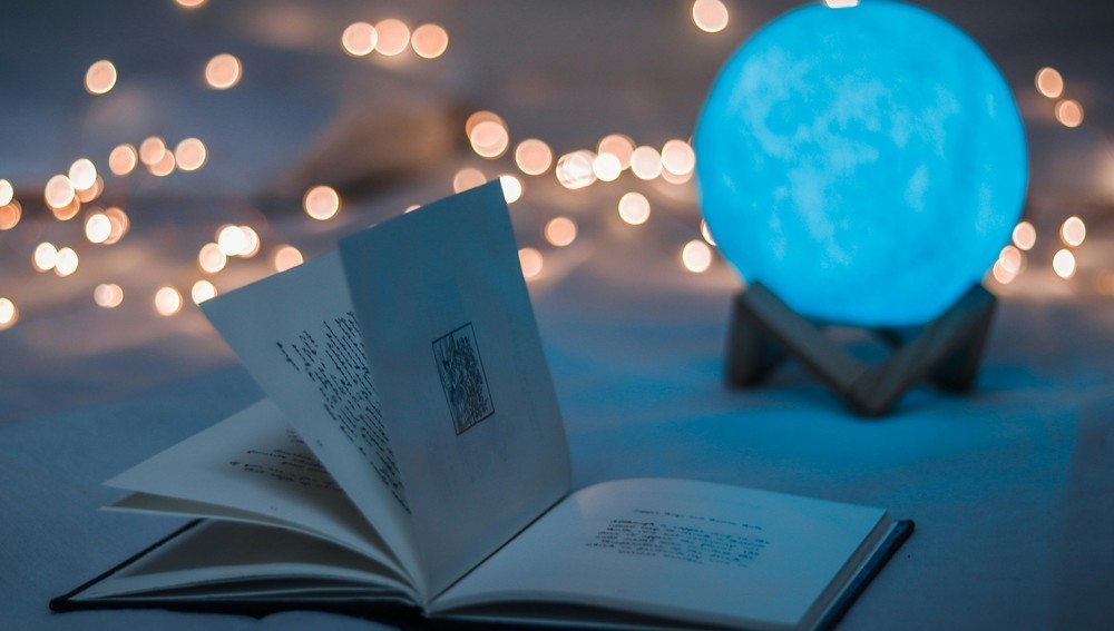 Aufgeschlagenes Buch neben einer Kristallkugel