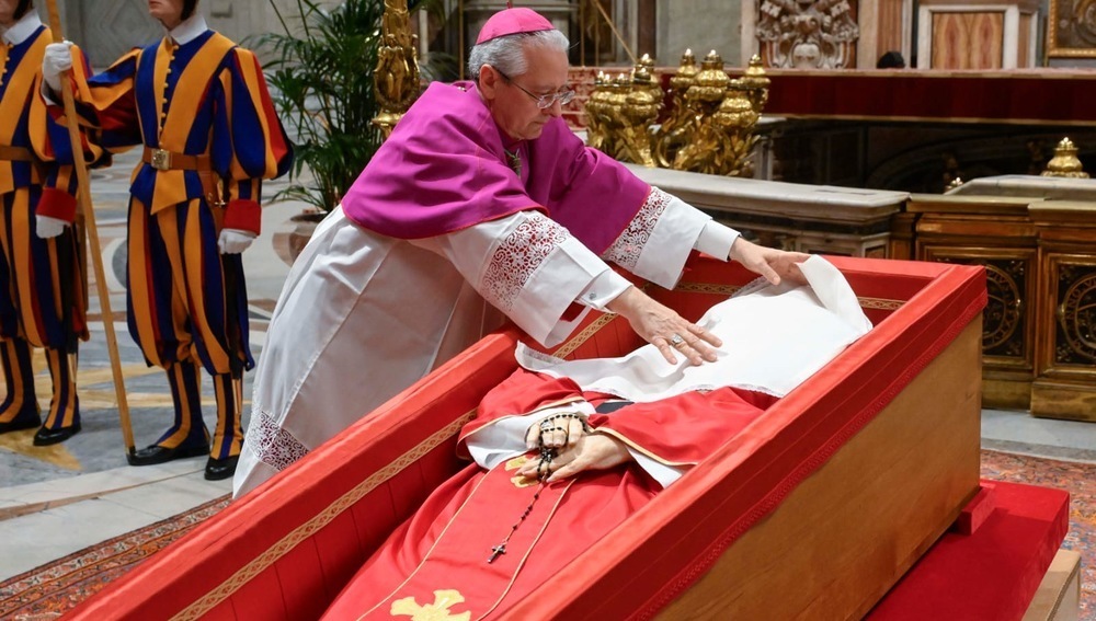 Päpstlicher Zeremonienmeister Diego Ravelli legt Papst Franziskus vor Sargschließung einen weißen Seidenschleier auf das Gesicht, am 25.4.2025 im Petersdom
