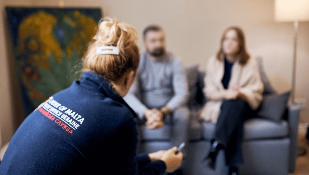 Familie im Gespräch mit Mitarbeiterin aus Psychosozialem Dienst von Malteser Ukraine
