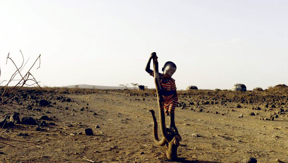 Afrikanisches Kind in trockener Landschaft